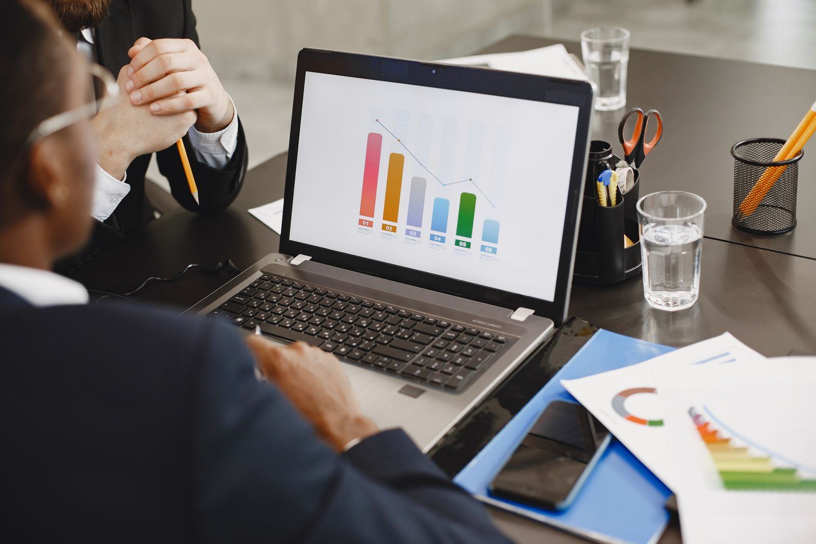 Affärsteam som analyserar en graf på laptop